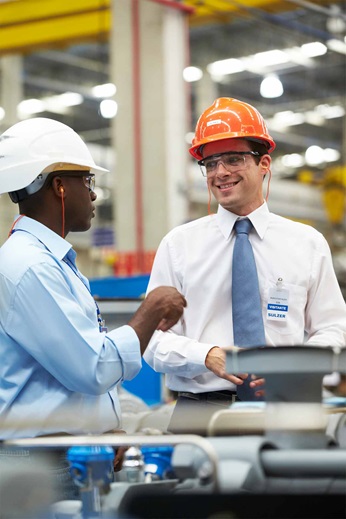 Three men inside the factory are talking